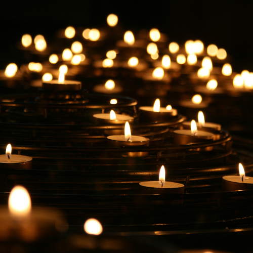 a long line of lit candles, representing generous thought leadership: spreading one spark so that it lights up others.