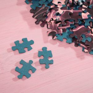 teal jigsaw puzzle pieces on a pink background